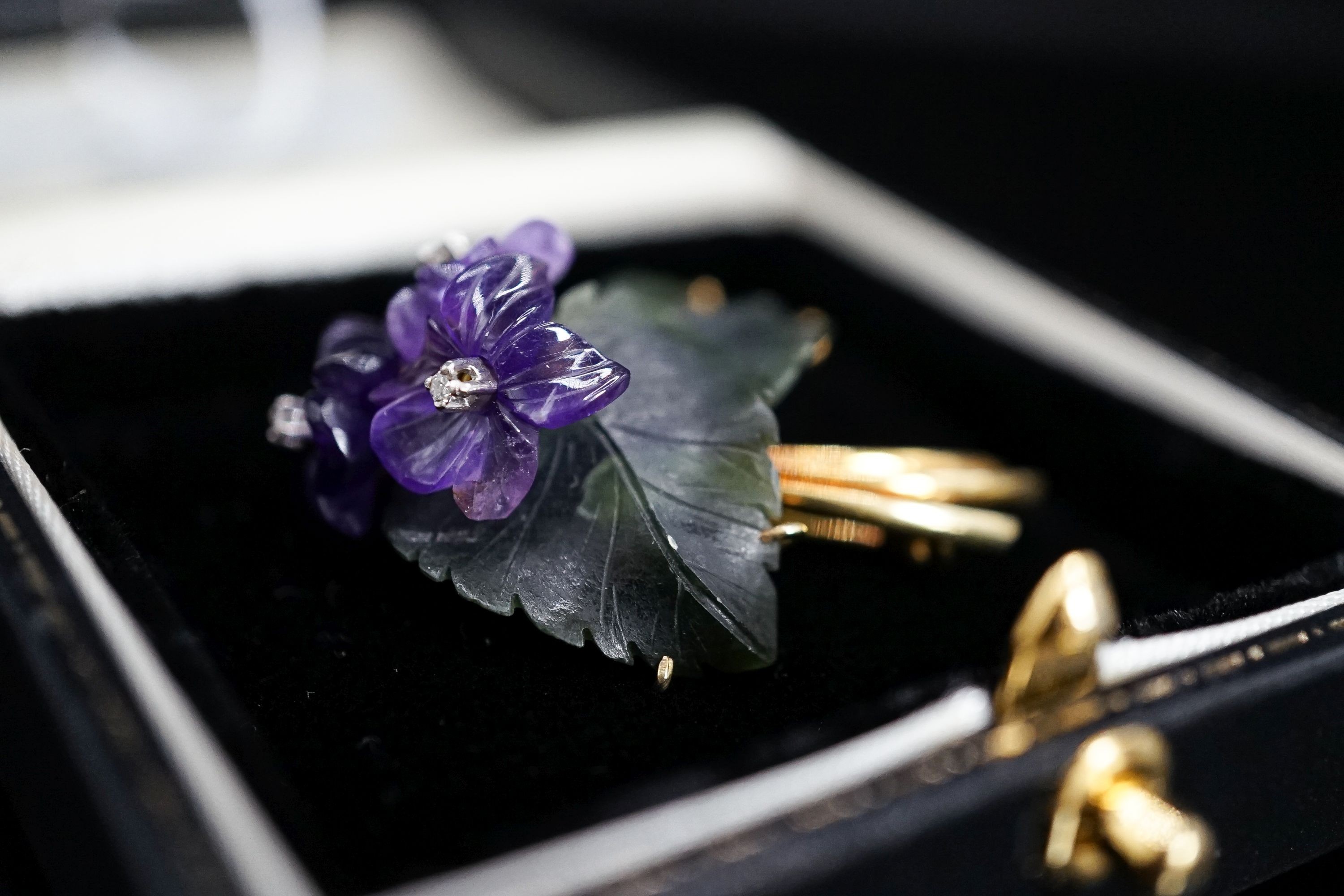 A continental Austrian? 585 yellow metal, diamond chip, carved nephrite and carved amethyst set flower head brooch, 39mm, gross 8.5 grams.